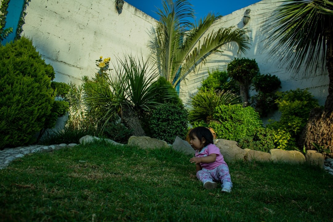 Documentary photographer crouching to photograph an elderly woman in her garden